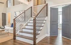 a staircase leading up to the second floor in a home with hardwood floors and white walls