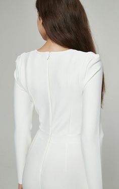 the back of a woman's white dress with long sleeves and an open shoulder