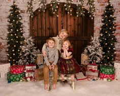 two children are sitting in front of christmas presents