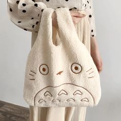 Introducing our My Neighbor Totoro Tote Bag – the epitome of softness and adorableness! Totoro's friendly face is skillfully embroidered on the front, ready to accompany you on your daily adventures. This compact tote is designed to carry your essentials with ease, making it the perfect companion for outings with friends. Available in both white and brown, you can choose the hue that suits your style. Whether you're strolling through the city or meeting up with pals, let Totoro's charm and your Totoro Bag, Fabric Handbags, Plush Bags, Handbag Outfit, Fabric Purses, My Neighbor Totoro, Tote Pattern, Hanging Bag, Casual Tote