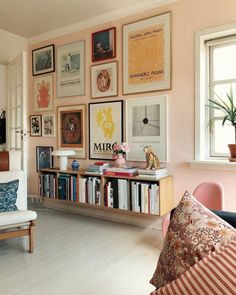 a living room filled with lots of furniture and pictures on the wall above it's bookshelf