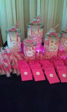 a table with pink candy and tags on it