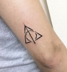 a person with a small tattoo on their arm that has a triangle and an eye in it