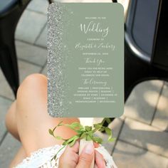 a person holding up a card that says wedding with silver glitter on the front and back