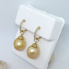 A very pretty (and practical) pair of natural color golden South Seas cultured pearl dangles with 14K yellow gold filigree floral caps dangle from a classic pair of 14K yellow gold diamond micro-pave' hinged hoop earrings.  The hoops can be worn alone, and the dangles can be removed and used as pendants. The pearls are oval drop shapes, 12mm in diameter; of a rich and mellow gold color with pink overtones and a very good luster.  There are some small pits which will not be noticeable when worn. These come from the Indonesian golden-lipped pearl oyster, and are natural in color. (The most accurate color is in the photograph with the earrings and pendant; sold separately.) The hinged hoops are 1.5mm wide, 13mm in diameter, and contain 0.15cttw of natural mined diamonds.  Pearls are a birthst Convertible Earrings, Pearl Oyster, 30th Wedding Anniversary, Oyster Pearl, Gold Filigree, South Seas, Boston Ma, Micro Pave