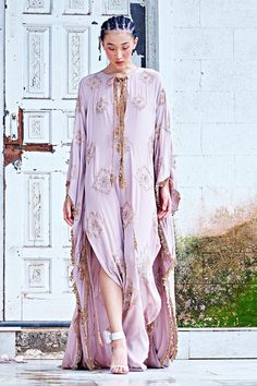 Dust rose habutai silk kaftan with round neck, all over Mughal pattern, thread, cut dana, sequin, beads hand embroidery and mirror work hem.
Components: 1
Pattern: Embroidered
Type Of Work: Thread, Beads, Cut Dana, Mirror and Sequin Work
Neckline: Keyhole Round Neck
Sleeve Type: Kimono Sleeves
Fabric: Habutai Silk
Color: Pink
Other Details: 
Side slits
Embellished tassels
Closure: Front tasselled tie-ups
Occasion: Cocktail,Destination Wedding - Aza Fashions Beads Hand Embroidery, Mughal Pattern, Kaftan Women, Thread Beads, Kaftan For Women, Pink Thread, Silk Kaftan, Kimono Sleeves, Mirror Work