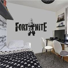 a bedroom with a bed, desk and computer on the wall in front of it