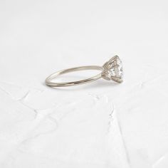 Round cut focal diamond of your choice. Need help choosing a diamond? Our Customer Care team is right here. This design features an open basket setting with six prongs on a delicate 1.2mm band—available in platinum or 14k solid yellow, white or rose gold. The band is accented by two (2.5mm) round white diamonds, one on each side of the focal stone. All accent diamonds are SI clarity and G+ color. We handcraft each piece with responsibly sourced 14k gold and ethically sourced stones. Single Diamond Lab Grown Diamond Ring For Wedding, Wedding Ring With Single Lab Grown Diamond, Wedding Diamond Ring With Single Lab-grown Diamond, Classic Cut Diamond Promise Ring, Classic Cut Diamond Jewelry For Promise, Classic Cut Diamond Wedding Ring With Prong Setting, Wedding Lab Grown Diamond Ring, Minimalist Marquise Cut Vvs Diamond Ring, Minimalist Marquise Cut Diamond Ring With Vvs Clarity