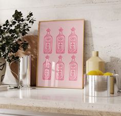 an art print on a shelf next to a potted plant and vases with lemons