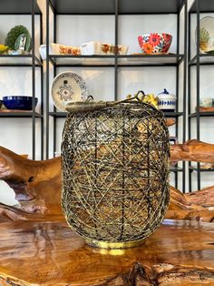 a vase sitting on top of a wooden table next to shelves filled with plates and bowls