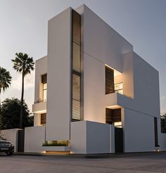 a white building with multiple windows and palm trees in the background