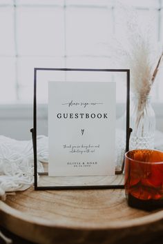 a guest book next to a candle on a table