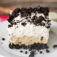 a close up of a piece of cake on a plate with cookies and cream frosting