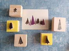 four rubber stamps with trees on them sitting next to a piece of paper that says christmas