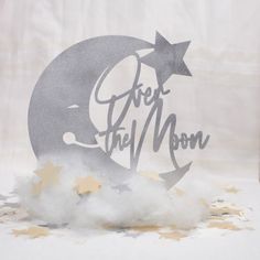 a cake topper with the words over the moon on it and stars around it