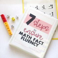 the seven steps to ensure math fact flueny book next to dices and numbers