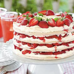 a large cake with strawberries on it sitting on a table