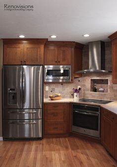 a kitchen with wooden floors and stainless steel appliances