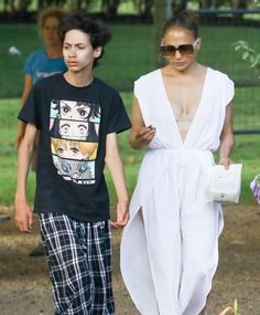 a man and woman walking down a dirt road