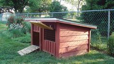 a dog house in the grass with a ramp leading up to it's door