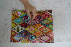 a person is making a patchwork quilt on the wall with their hands and fingers