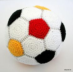 a crocheted soccer ball sitting on top of a white table