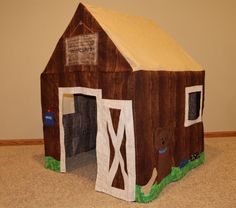 a wooden house made to look like a barn with a dog in the front door