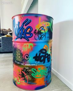 there is a colorful barrel with graffiti on it