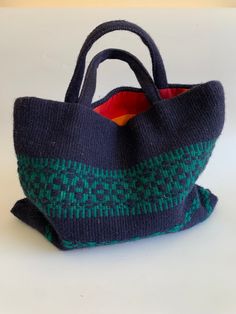 "This is a beautiful tribal handwoven handbag, made of wool yarn and cotton lining. This bohemian purse is navy blue color with a hint of green. It has two handles and open top. The interior is lined in red checkered cotton fabric. This woven wool purse has one compartment and one slip pocket. Era: 90s Condition: This woven handbag is beautifully preserved. It does have some minor flaws, due to the texture of the wool fabric - it has caught some fine fibers and tiny straws, which I have tried to Bohemian Green Crochet Bag With Large Capacity, Handwoven Blue Square Bag, Blue Handwoven Square Bag, Blue Square Handwoven Shoulder Bag, Blue Square Handwoven Bag, Bohemian Green Bag With Double Handle, Traditional Blue Tote Bag, Rectangular Travel Bag With Weaving Work, Traditional Blue Shoulder Bag For Everyday Use