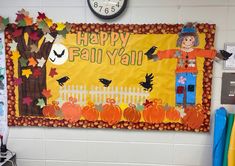 a bulletin board with a scarecrow and pumpkins on it in front of a clock