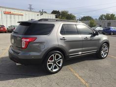 the rear end of a silver ford explorer parked in a parking lot with other cars