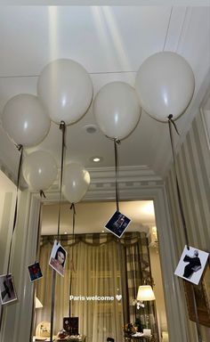 some white balloons hanging from the ceiling in a room