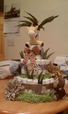 a giraffe diaper cake on top of a table with stuffed animals around it