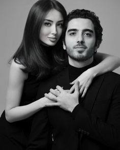 a man and woman are posing for a black and white photo with their arms around each other