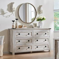 a white dresser sitting next to a window with a mirror on it's side