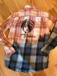 a women's flannel shirt with the word warrior on it and a woman's face