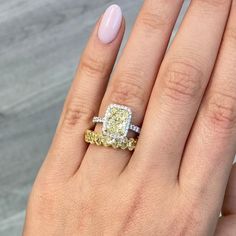 a woman's hand with two different colored diamond rings on her left and right fingers