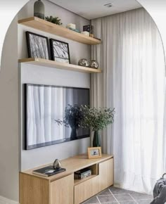 a living room filled with furniture and a flat screen tv on top of a wooden shelf