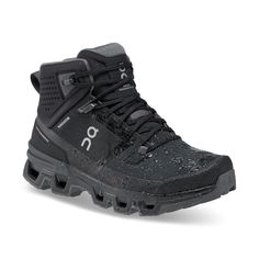 a pair of black hiking shoes with the word on the side and grey soles