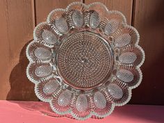 a decorative glass dish sitting on top of a pink table