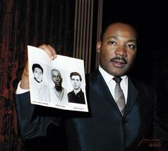 a man in a suit holding up an old photo