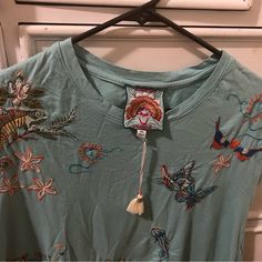 This Johnny Was T-Shirt Is Perfect For Any Occasion, Whether You're Going Out For A Casual Day Or A Night Out, This Top Is A Great Choice. The Shirt Is Made Of 100% Cotton And Features A Crew Neckline, Puff Short Sleeves, And Beautiful Bird Flower Ufo Embroidery Accents. Bohemian Short Sleeve Tops For Loungewear, Bohemian Cotton Tops For Loungewear, Blue Bohemian Tops For Loungewear, Bohemian Blue Tops For Loungewear, Bohemian Blue Top For Loungewear, Blue T-shirt For Spring Loungewear, Beautiful Bird, Johnny Was, Beautiful Birds