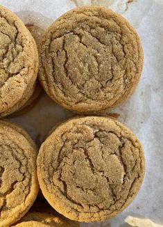 four cookies are stacked on top of each other in a pile with wax paper behind them