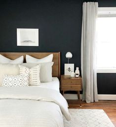 a bed room with a neatly made bed and two pictures on the wall above it