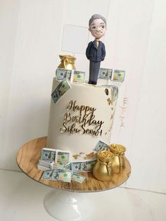 a birthday cake decorated with money and a figurine