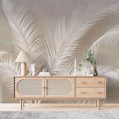 the sideboard is made from wood and has white palm leaves on it, along with a lamp