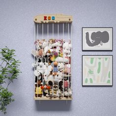 there is a rack with stuffed animals in it on the wall next to two pictures