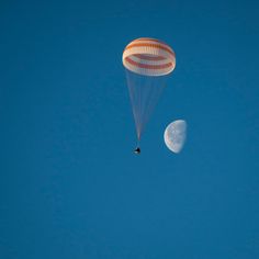 a person is parasailing in the sky with a half - moon behind them