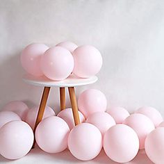 there is a cake stand with pink balloons on it