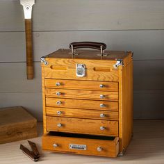 an old fashioned wooden toolbox sitting on top of a table next to a hammer